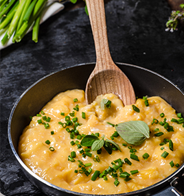 scrambled egg in frying pan with chopped chives