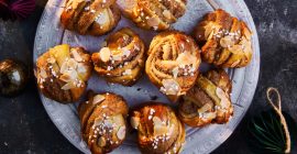 Orange and almond Christmas pastry buns on a silver plate.