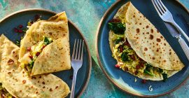 Two savoury crepes, containing pancetta and leek against a blue background.