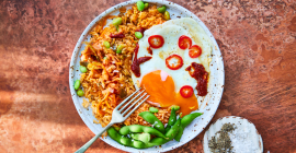 Kimchi fried rice with chillis and a golden yolked Clarence Court egg.