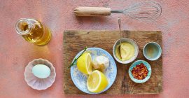 Clarence Court roasted garlic mayonnaise alongside an egg, olive oil and kitchen equipment.