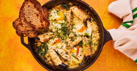 Cromer crab with Clarence Court eggs sit in a metal skillet, with two slices of toasted sourdough sitting on the side