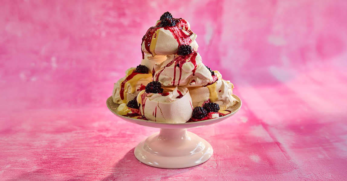 Blackberry pavlova stack with bay infused custard, blackberry compote and cream