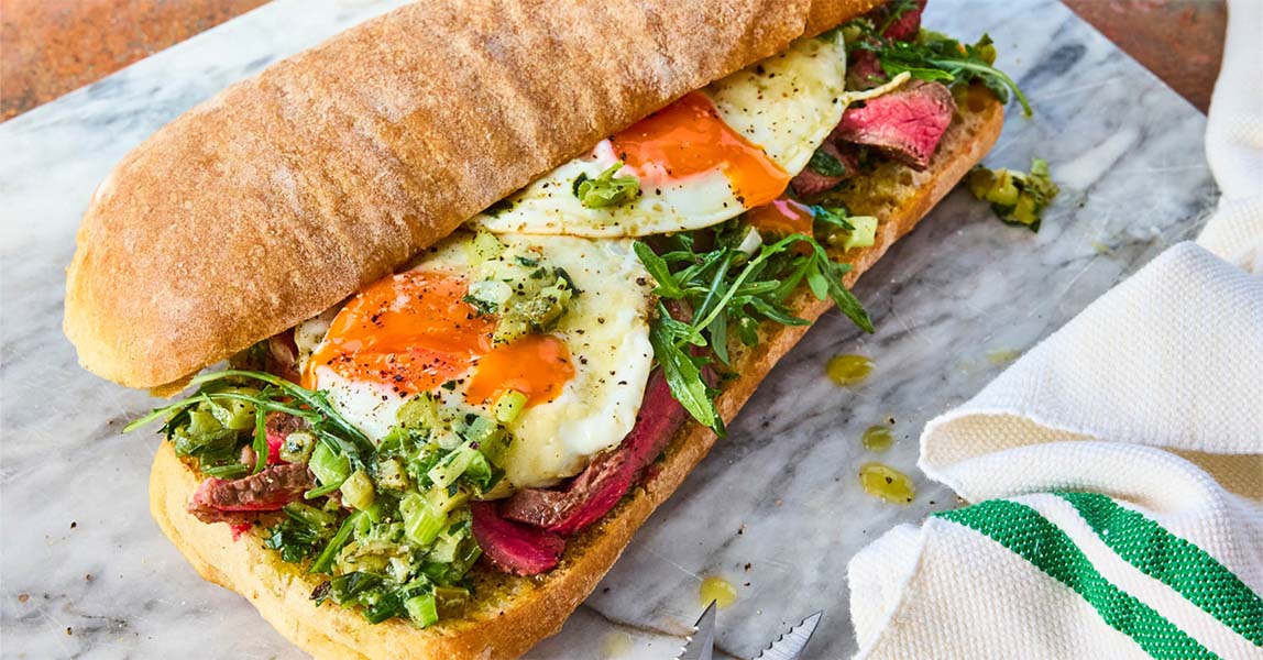 Steak sandwich with Parmesan eggs and green onion salsa